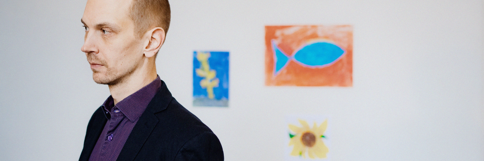 man standing in front of white wall, a drawing on the wall